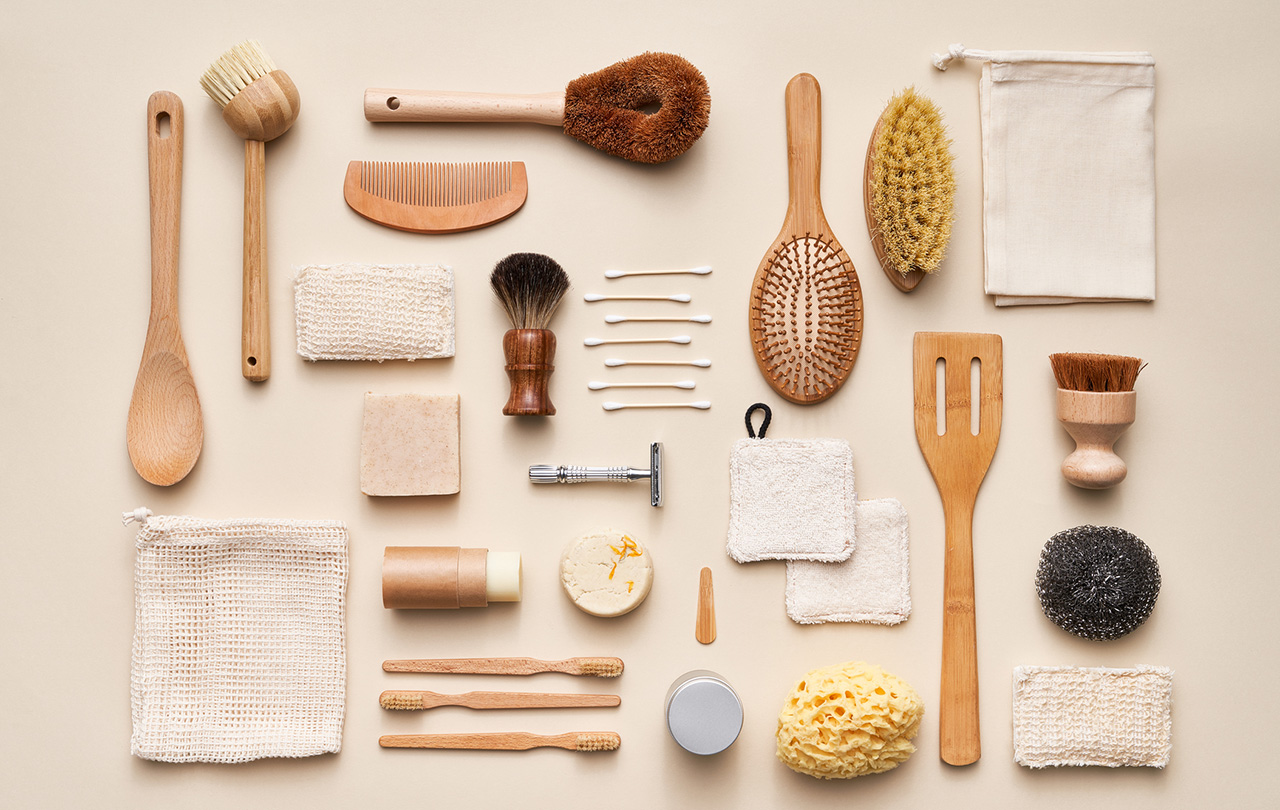 Sbírka různých přírodních kosmetických produktů a bambusových opakovaně použitelných nástrojů umístěných na béžovém pozadí